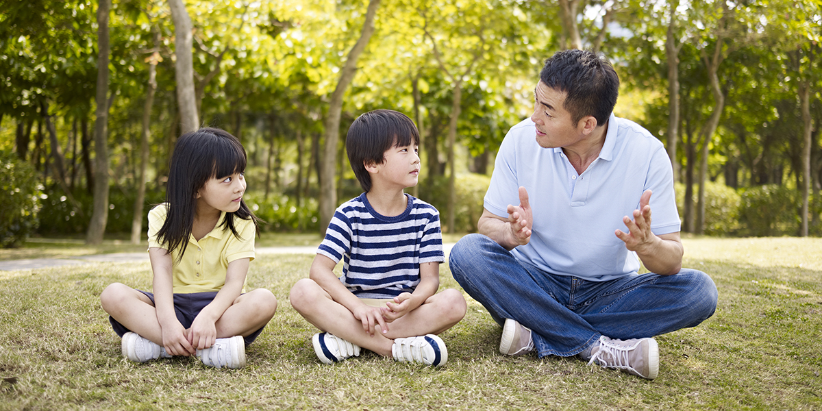 father talking to two children